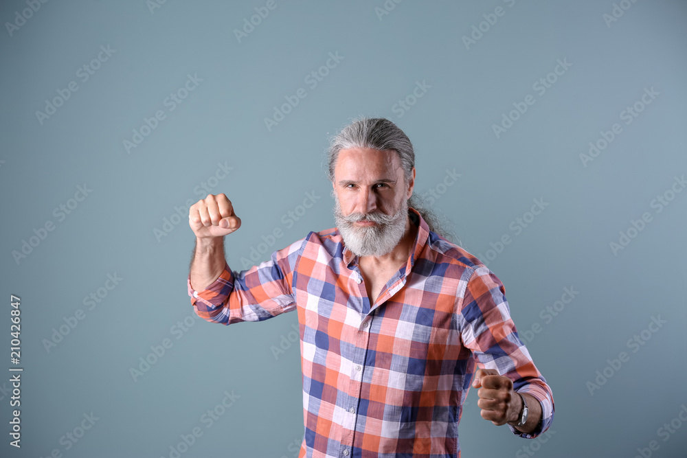 Fototapeta premium Handsome bearded mature man on color background