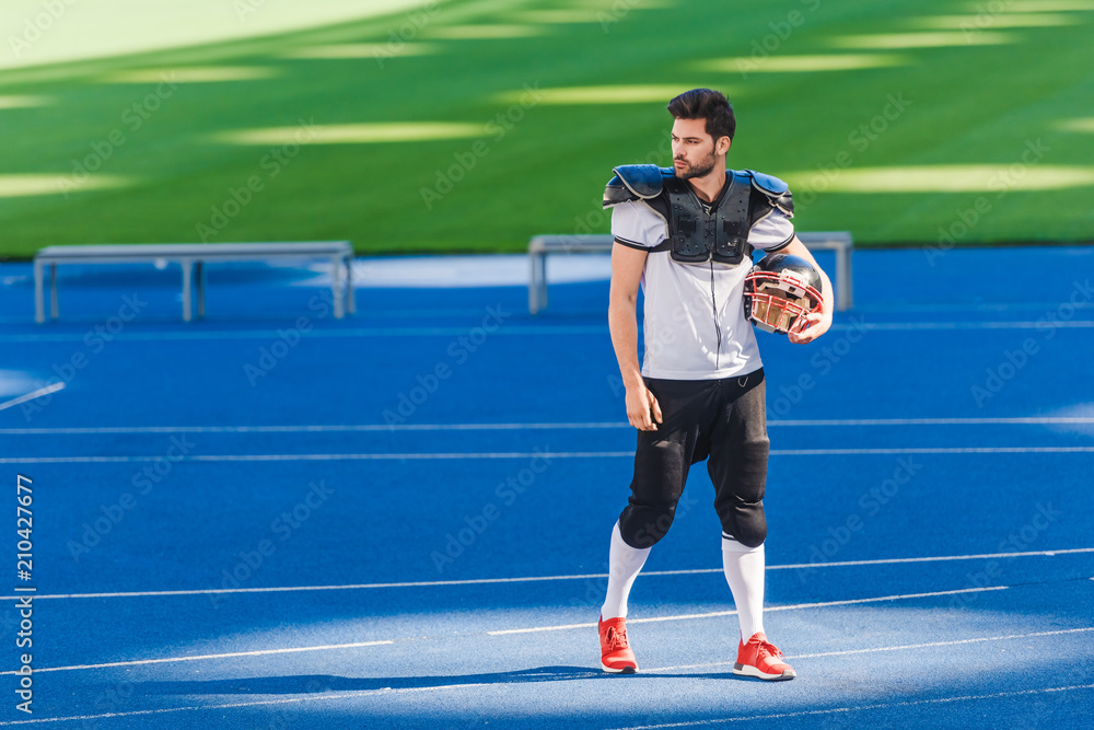 attractive young american football player standing alone at sports stadium attractive young american football player standing alone at sports stadium