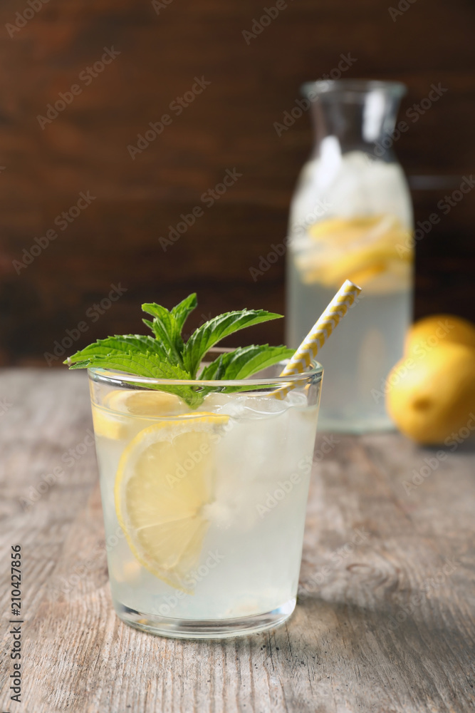 Natural lemonade with mint in glass on wooden table Natural lemonade with mint in glass on wooden table