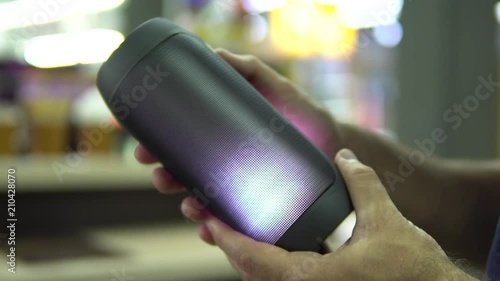 Portable speaker glows in hand.