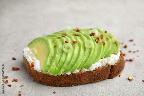 Crisp rye toast with sliced avocado and cream cheese on table
