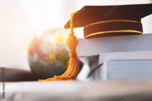 Graduated or Graduation university study abroad international Conceptual, Master cap on books stack with blur of america earth world globe model map in Library room of campus, Back to School photo