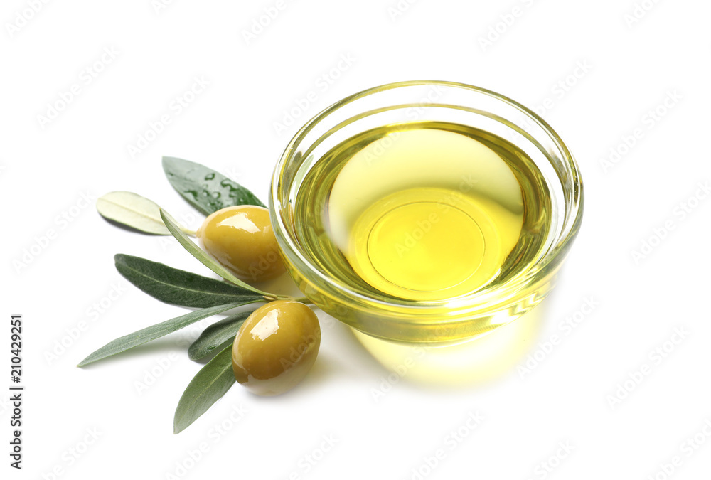 Little bowl with oil, ripe olives and leaves on white background