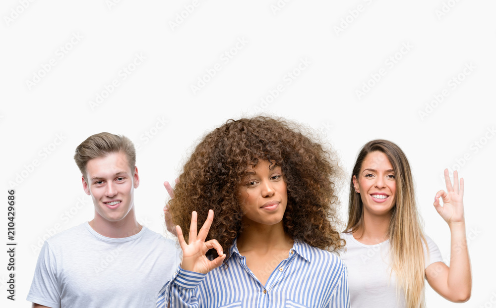 Group of young people over white background doing ok sign with fingers, excellent symbol Group of young people over white background doing ok sign with fingers, excellent symbol