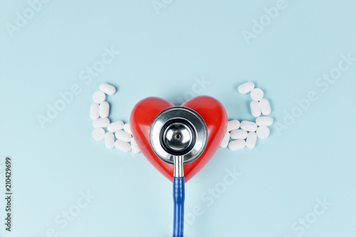 Red heart abstract concept with strong arms medicine, and check by stethoscope on blue background..