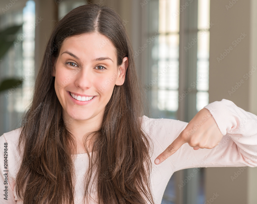 Young beautiful woman at home with surprise face pointing finger to himself Young beautiful woman at home with surprise face pointing finger to himself