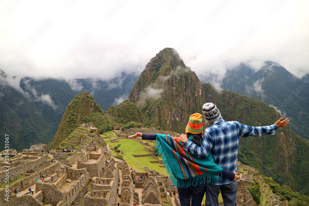 Couple admiring the spectacular view of Machu Picchu, UNESCO World Heritage site in Cusco Region, Urubamba Province, Peru - obrazy, fototapety, plakaty 