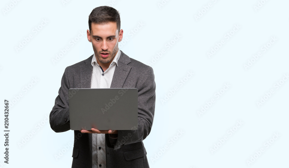 Handsome young man using computer laptop scared in shock with a surprise face, afraid and excited with fear expression Handsome young man using computer laptop scared in shock with a surprise face, afraid and excited with fear expression