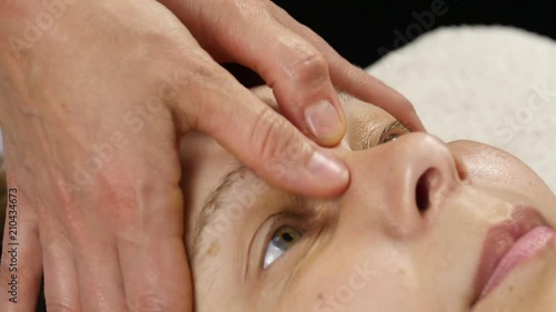 plastic face massage in spa saton. woman enjoys the services of a professional massage therapist. 4K photo