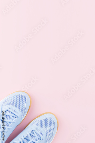 Violet female sneakers on pink background. Flat lay, minimal background.