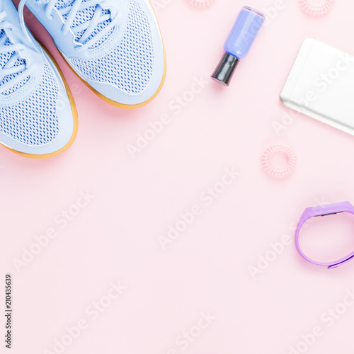 Woman sneakers  fitness tracker and smartphone on pastel pink background. Sport fashion concept. Flat lay