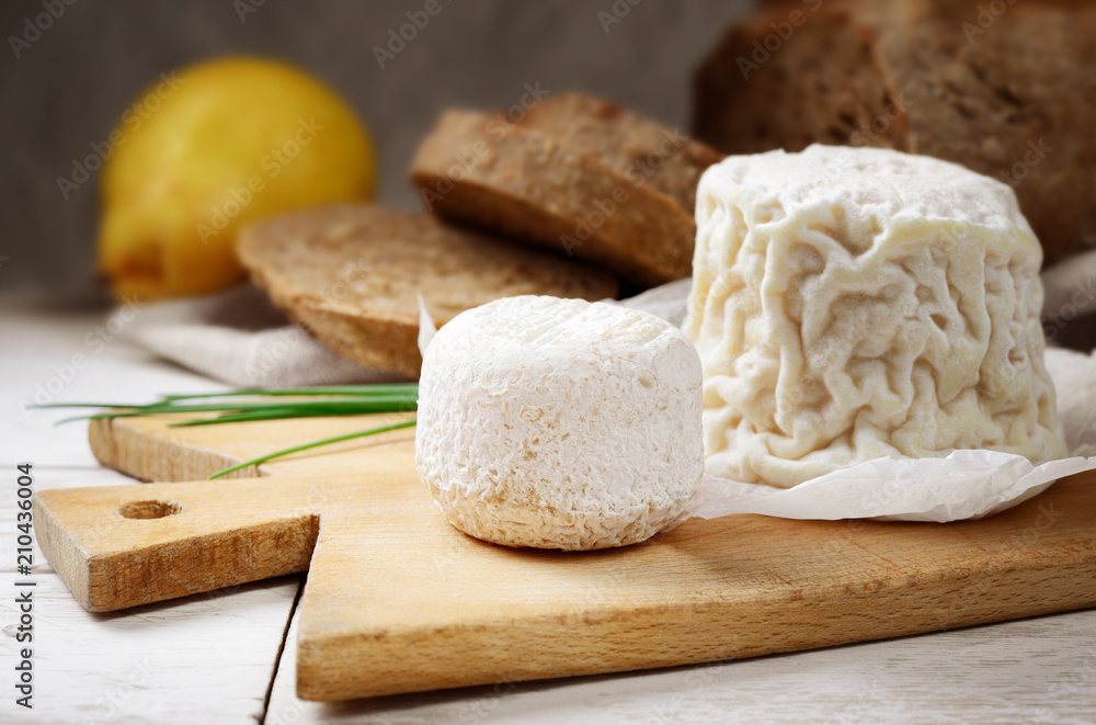 French goat cheese on chopping board. French goat cheese on chopping board.