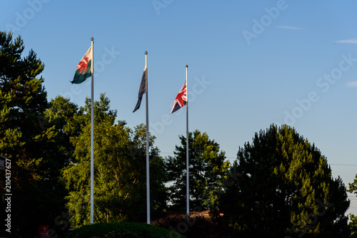 Wales and British flags blowing in the wind above trees on a golf resort
