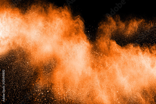 abstract explosion of orange dust. abstract orange  powder splatter on black  background. Freeze motion of orange  powder splash.