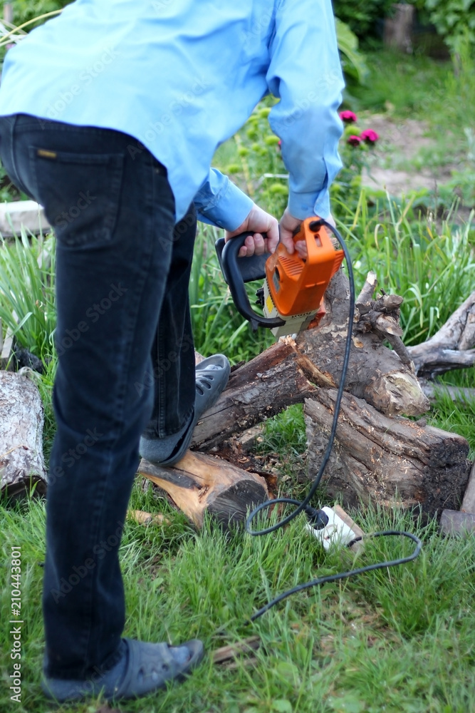 A man with an electric saw cuts a tree A man with an electric saw cuts a tree