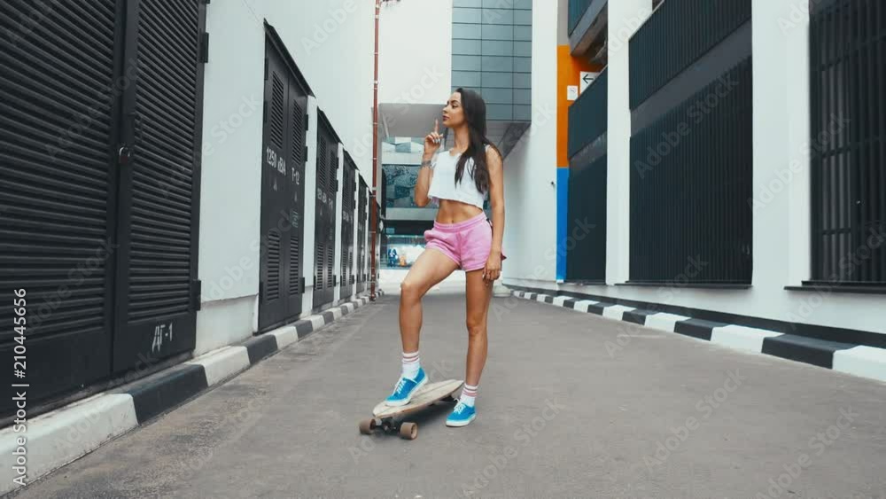 CINEMAGRAPH - seamless loop. Young stylish Caucasian female posing with a longboard outdoors. 4K UHD CINEMAGRAPH - seamless loop. Young stylish Caucasian female posing with a longboard outdoors. 4K UHD