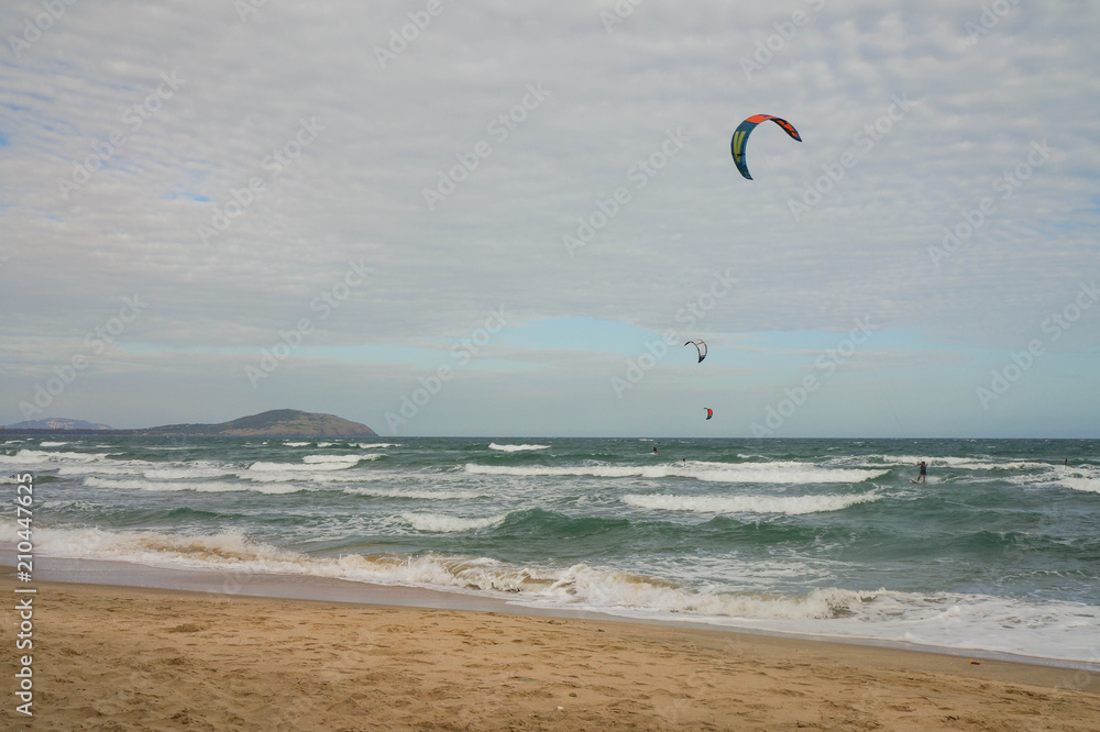 Picturesque view of the coast with kite surfers on waves. Picturesque view of the coast with kite surfers on waves.