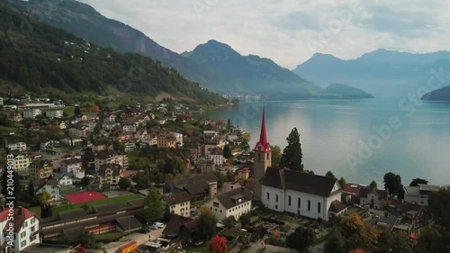 Lake Lucerne Switzerland aerial view. Flying above Weggis village on Swiss alps lake in the fall. Drone footage of picturesque hilltop village and countryside in autumn. photo