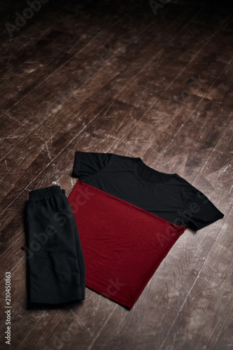 Fototapeta Naklejka Na Ścianę i Meble -  Black and red shirt with black shorts on wooden floor