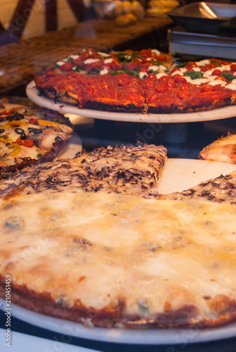 Slice of pizza exposed in a bakery