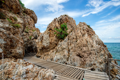 The wooden walkway  beside rock leading to the beach in Thailand
