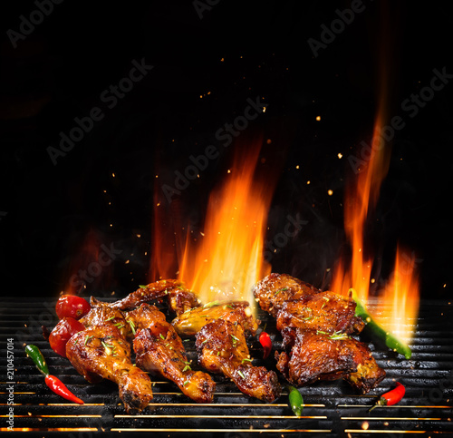 Various chicken meat being grilled, isolated on black