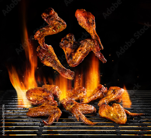 Flying pieces of chicken meat on grill