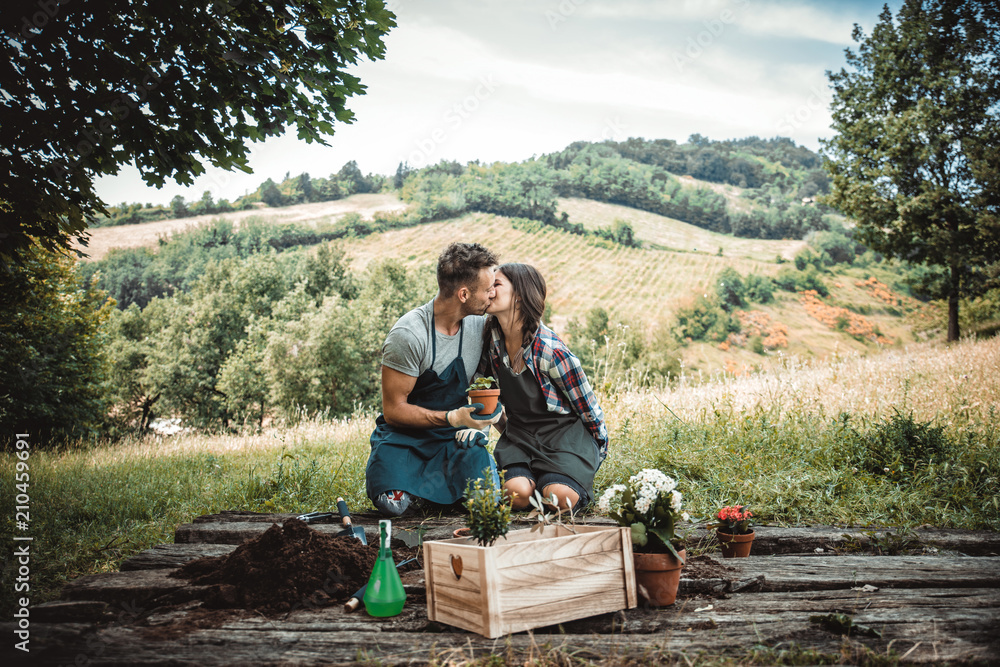 Couple relaxing and planting some flowers in their countryside house yard Couple relaxing and planting some flowers in their countryside house yard