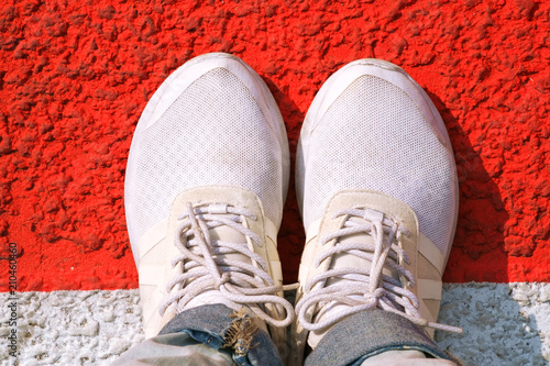 Top view of white sneakers on crossing.