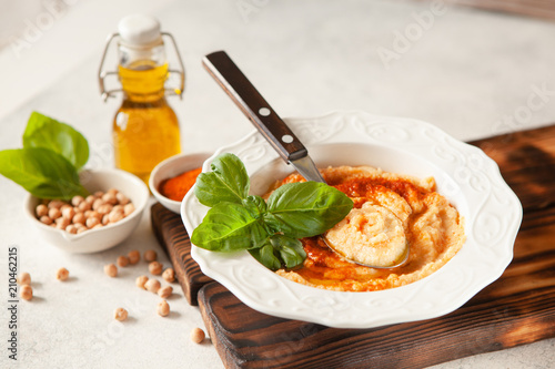 Fresh classic hummus with basil in the bowl