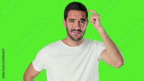 Confused young man on chroma screen