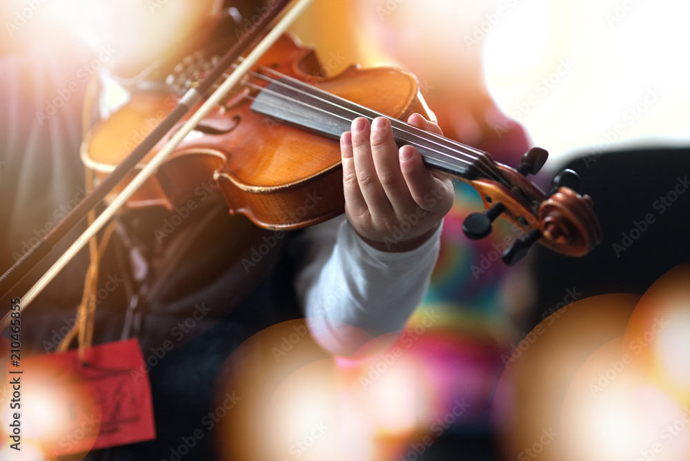 Fototapeta premium Child playing the violin in room