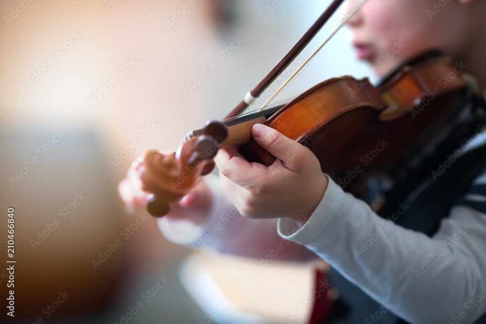 Fototapeta premium Child playing the violin in room 