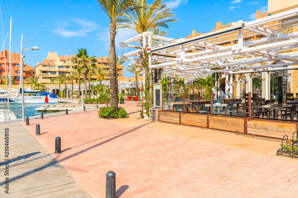 Beautiful Sotogrande marina with colorful houses and palm trees on coastal promenade, Costa del Sol, Spain