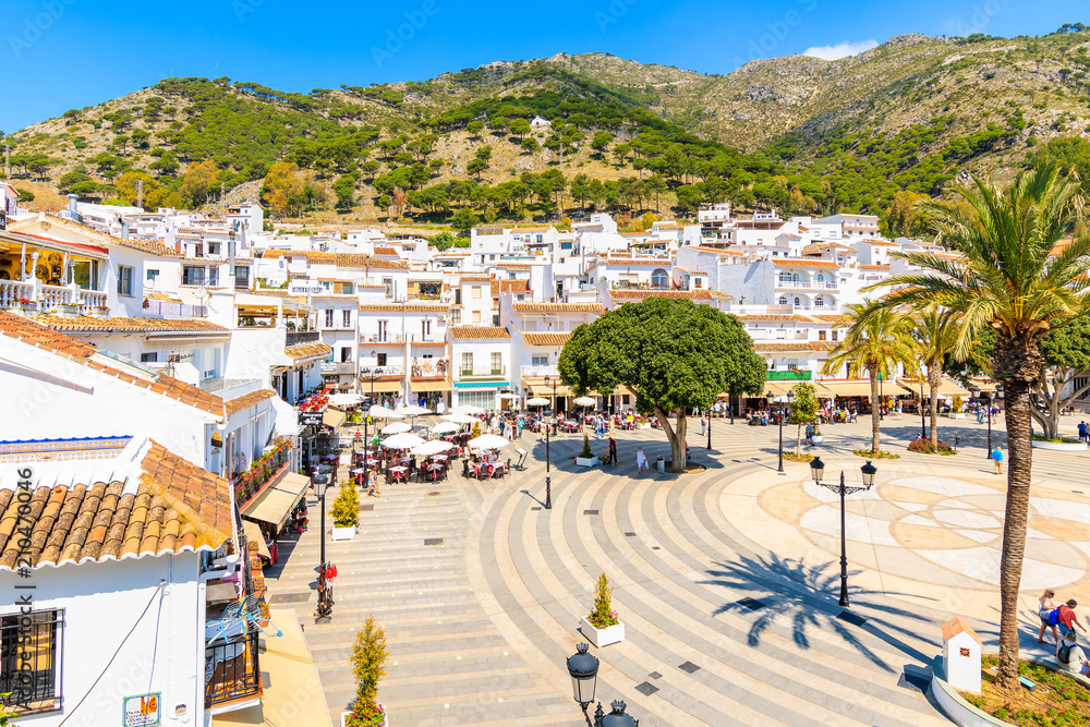 MIJAS VILLAGE, SPAIN - MAY 9, 2018: Main square with houses in picturesque white village of Mijas, Andalusia. Southern Spain is famous for mountain villages with white architecture. - obrazy, fototapety, plakaty 