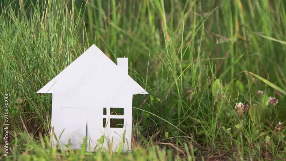 cardboard house made of paper on a background of green grass cardboard house made of paper on a background of green grass