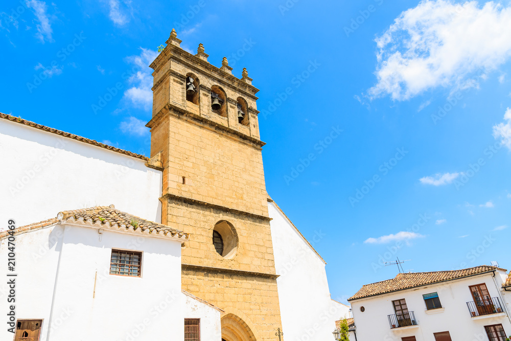 White facade and tower of church building in Andalusian village of Ronda, Spain