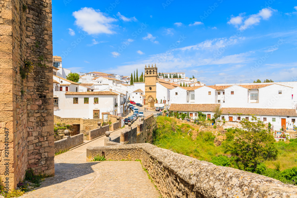 Walkway from castle to Andalusian village of Ronda with white houses, Spain