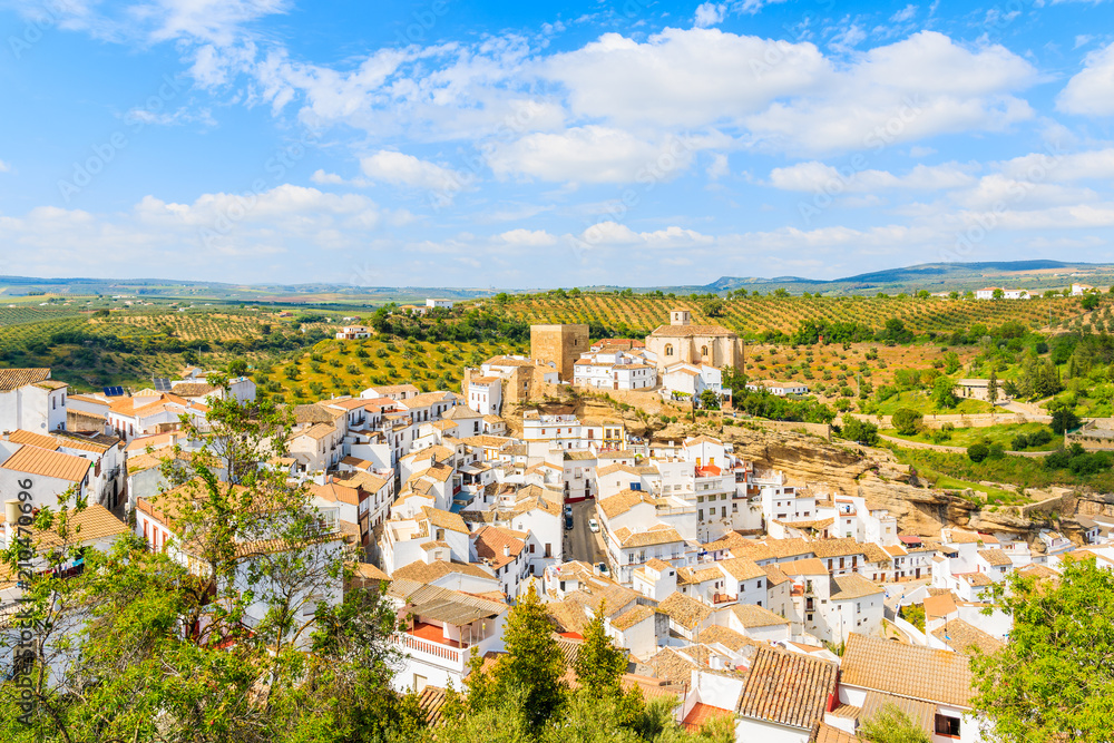 Church on hill top and white houses of Andalusian village during sunny day, Sentinel de las Bodegas, Spain