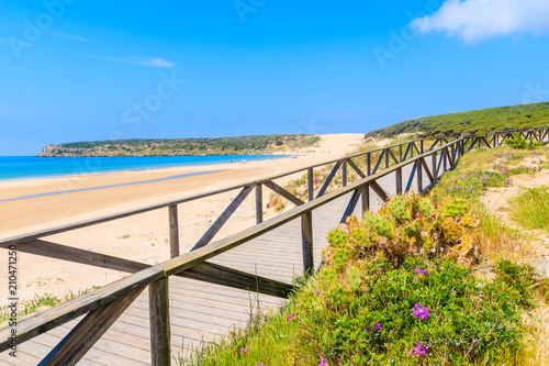 Coastal walkway along blue sea on white sand Bolonia beach, Andalusia, Spain