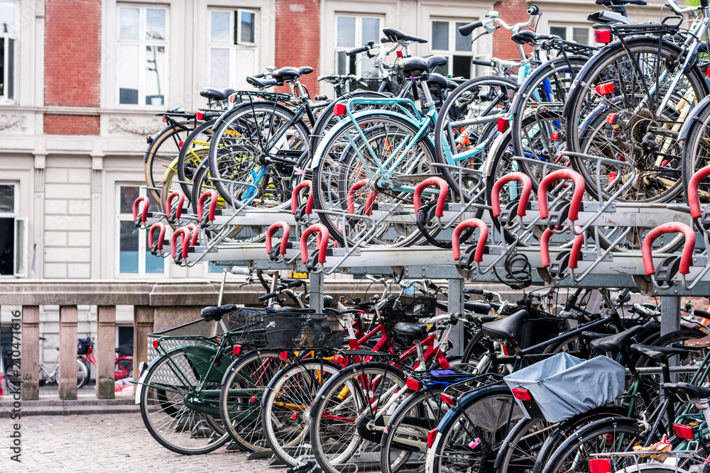 A lot of bicycles stacked on a bike rack
