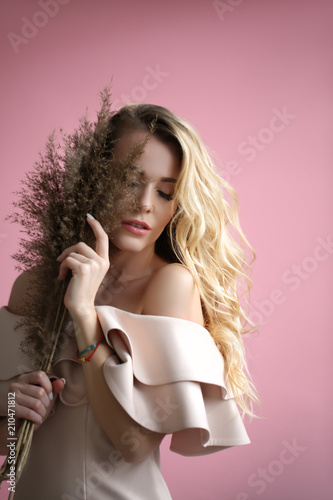 Portrait of a blonde in the dress with a plant