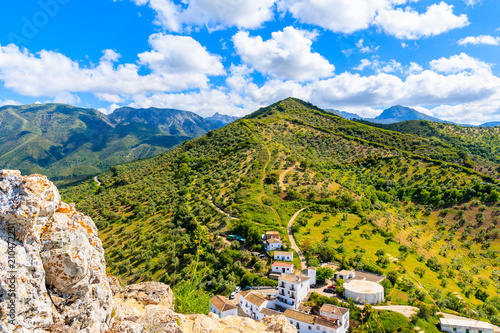 Fototapeta View of mountains and houses on green hills in Zahara de la Sierra village, Anda