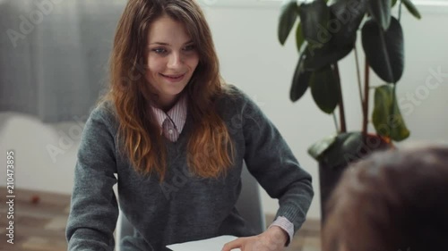 Attractive woman, mother of sick girl sitting near bed, holding hand of daughter. Sad ill girl laying on hospital bad. Close-up. Endemic disease.