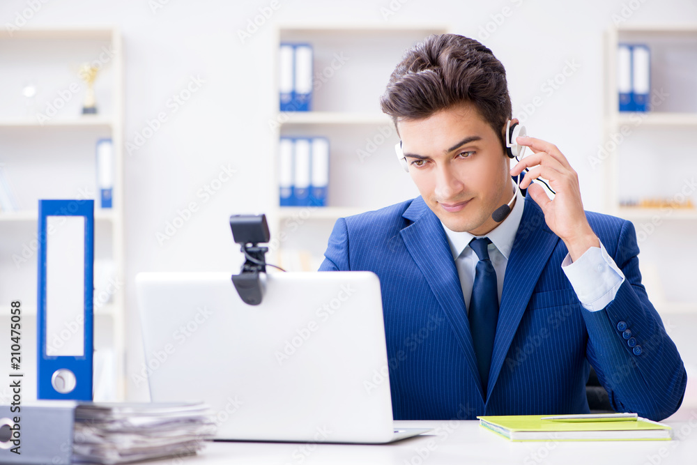 Naklejka premium Young help desk operator working in office