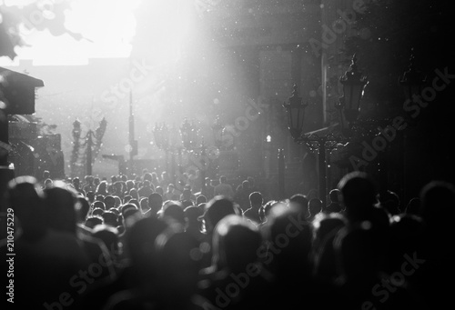 Obraz na plátně Black and white silhouette of people crowd walking down the pedestrian street un