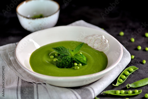 Healthy cream soup of fresh green peas with broccoli and mint
