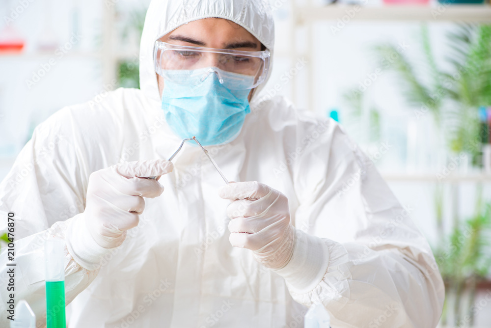 Male biochemist working in the lab on plants Male biochemist working in the lab on plants