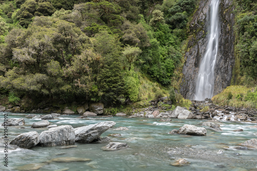 Thunder Creek Falls in Mt Aspiring National Park  with the Haast River in the foreground. Mt Aspiring National Park  West Coast  New Zealand.