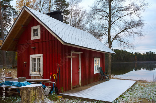 The Finnish house of red color on the lake.